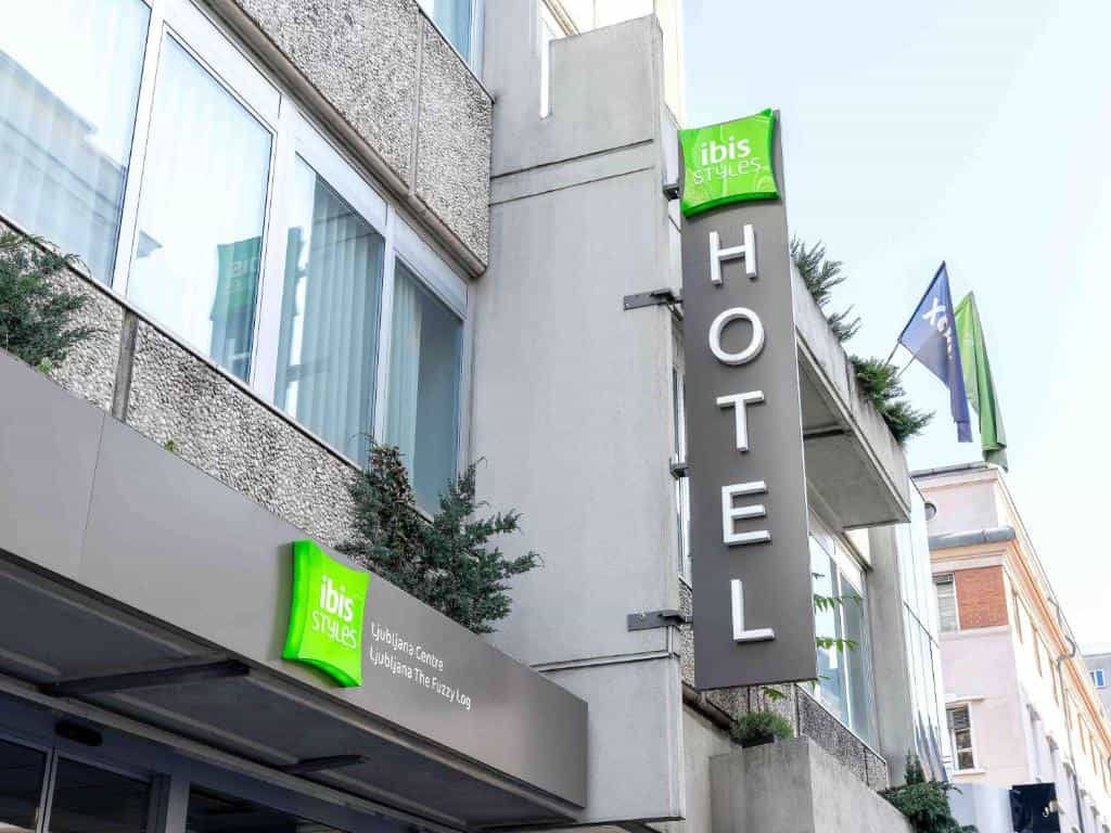 Ibis Styles Ljubljana Centre hotel exterior with vertical "HOTEL" sign and green logo.