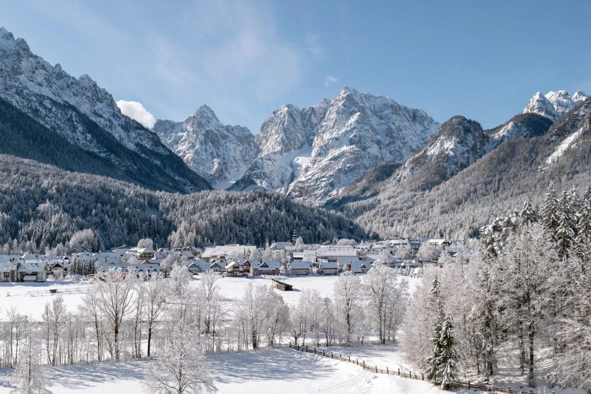 Winter village nestled in a valley below snow-covered alpine mountains in Kranjska Gora.